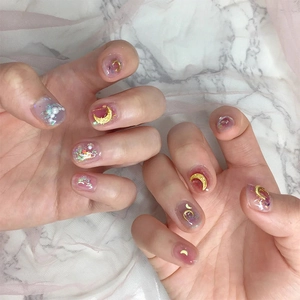 Star and moon nail art with gold studs and pearls on translucent ombre manicure nails