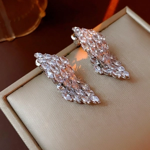 Macro shot of silver drop earrings with marquise-cut cubic zirconia on silk lining