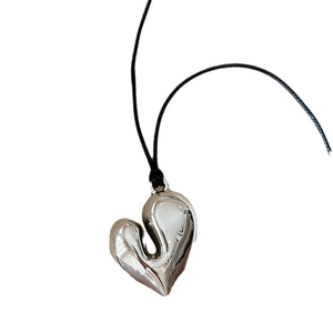Collana minimalista con pendente a cuore argento e cordino nero regolabile su sfondo bianco
