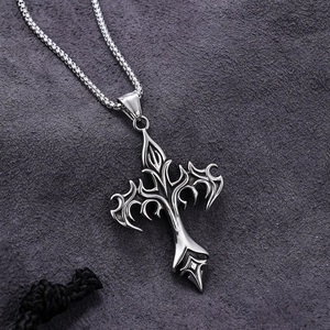Silver gothic flame cross pendant with square link chain on grey suede background