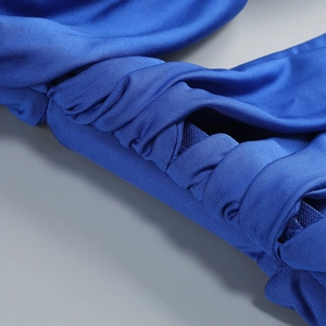 Macro detail of bright blue ruched fabric showing high elasticity and professional stitching