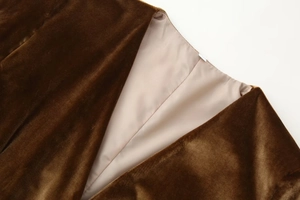 Detailed close-up of dark brown velvet fabric and smooth beige satin lining with fine stitching