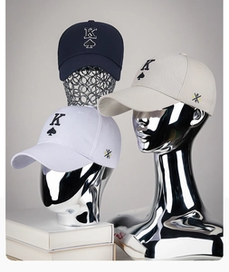 Detailed embroidery of King of Spades K logo on navy, white, and beige baseball caps