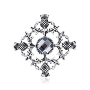 Detailed close-up of a silver Thistle brooch with dark grey faceted crystal stone