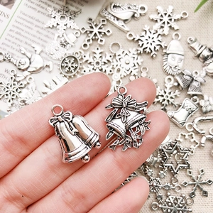 Macro detail of vintage silver alloy Christmas charms featuring bells and snowflakes