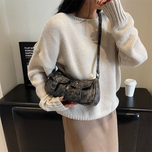 Vintage dark gray crescent shoulder bag with buckles in a lifestyle setting