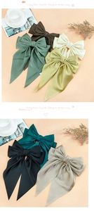 Detailed texture of satin bow hair clips in various Morandi colors with silk luster