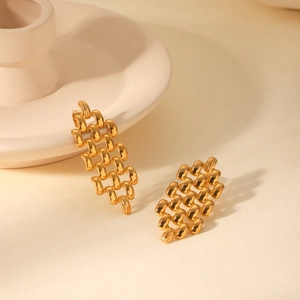 Détail de boucles d'oreilles en acier doré 18K avec texture de bracelet montre