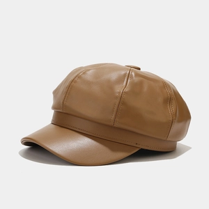 Detail shot of caramel faux leather newsboy cap showing stitching and panel construction