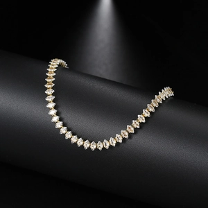 Close-up of gold marquise cut tennis bracelet with sparkling zircon stones on black pedestal