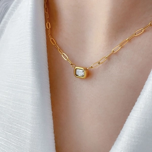 Detailed view of 18K gold plated titanium necklace with emerald-cut zircon on model