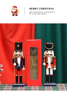 Gros plan de soldats casse-noisettes traditionnels avec boîte cadeau sur tissu écossais