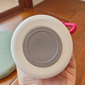 Close-up of stainless steel vacuum mug base with hand wash and care instructions