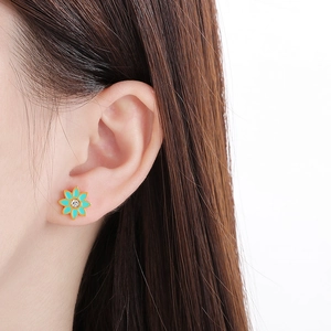 Détail d'une boucle d'oreille lotus vintage en émail vert menthe et pierre de zircon
