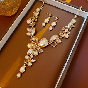 Details eines luxuriösen goldenen Schmucksets mit Blumen und Tropfen in Box