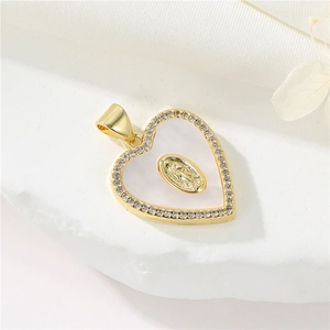 Close-up of heart-shaped 14K gold pendant with white shell and inlaid zircon stones