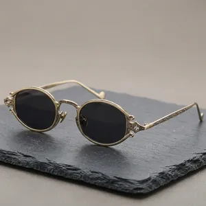 Steampunk gold metal sunglasses with oval engraved frames and dark round lenses