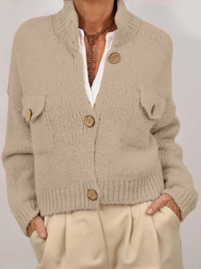 Detailed view of beige knit cardigan featuring wooden buttons and front chest pockets