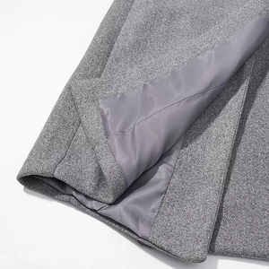 Detail showing the gray wool fabric texture and neat interior lining of the long slim coat