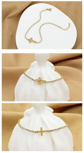 Macro shot of gold cross tennis bracelet with cubic zirconia on elegant fabric