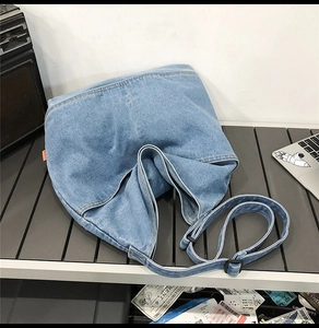 Detailed top view of soft light blue washed denim tote bag with adjustable shoulder strap