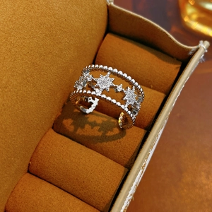 Macro detail of silver double-layered star ring with zircon stones in brown velvet box