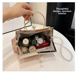 Top view of spacious handbag interior with cosmetics and elegant pearl clasp detail