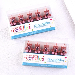 Detailed view of two boxes featuring brown teddy bear-shaped candles for birthday cakes