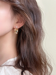 Gros plan de boucles d'oreilles grappe de raisin en résine champagne avec perle