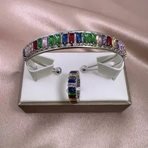 Detalle del conjunto de brazalete y anillo ajustable con circonitas de colores talla baguette