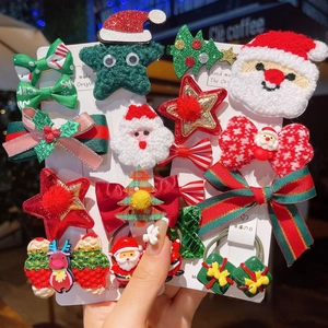 Detailopname van handgemaakte kersthaarspelden met kerstman, rendier en sterren