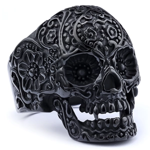 Macro shot of black sugar skull ring with detailed floral engravings and punk aesthetic