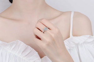 Close-up of heart-shaped diamond ring with pave-set stones on a female model