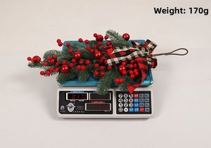 Detailed view of 170g Christmas swag with red berries and black buffalo plaid bow
