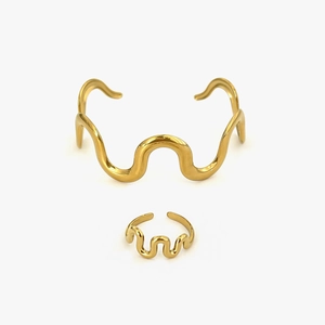 Golden wavy jewelry set featuring an open cuff bracelet and a minimalist matching ring