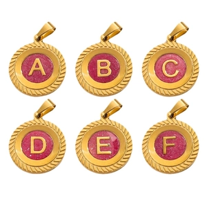 Pendentifs alphabet ronds dorés avec émail pailleté rose et bordure à texture torsadée