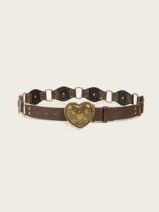 Detail of vintage heart-shaped engraved metal buckle on a dark brown leather belt