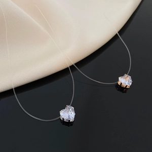 Macro shot of heart-shaped zircon pendants on transparent fishing line necklaces