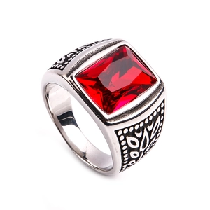 Detailed close-up of a silver ring featuring a large square red stone and vintage textures
