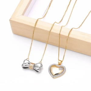 Bow pendant and heart locket necklace with zircon inlay on a minimalist wood frame
