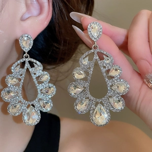 Detailed close-up of crystal-encrusted hollow teardrop earrings on silver pins