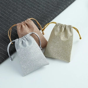 Macro view of sparkly drawstring gift bags in gold, silver, and rose gold finish