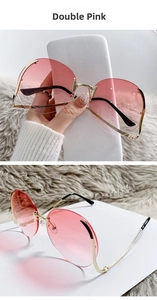 Detail of rimless round sunglasses with pink gradient lenses and golden metal frame