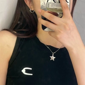 Silver star pendant necklace with delicate beaded metal chain worn on neck for women