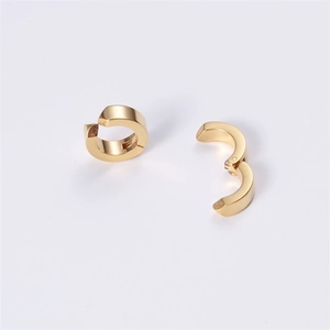Detail of gold clip-on earrings showing hinge mechanism and smooth metallic finish