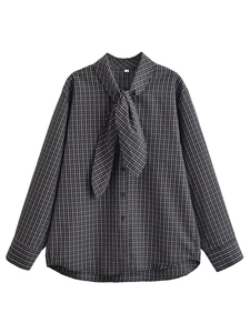 Gros plan détaillé sur l'étiquette taille S et la texture d'une chemise à carreaux