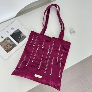 Detail of purple velvet tote bag featuring pearl embellishments and Sozakka brand tag