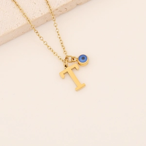 Détail du collier doré avec pendentif lettre T et perle œil bleu en acier inoxydable