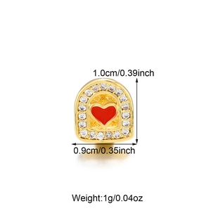 Detail shot of a gold-plated hip-hop tooth grill with red heart zircon and dimensions