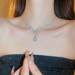 Close-up of model wearing V-shaped silver necklace with sparkling water-drop zircon pendant